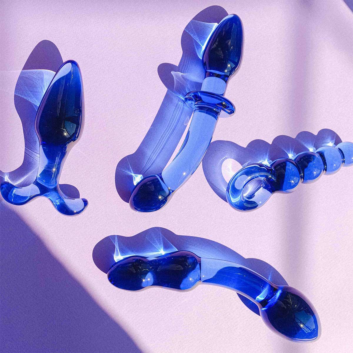 Blue silicone butt plug sex toys set on a white background