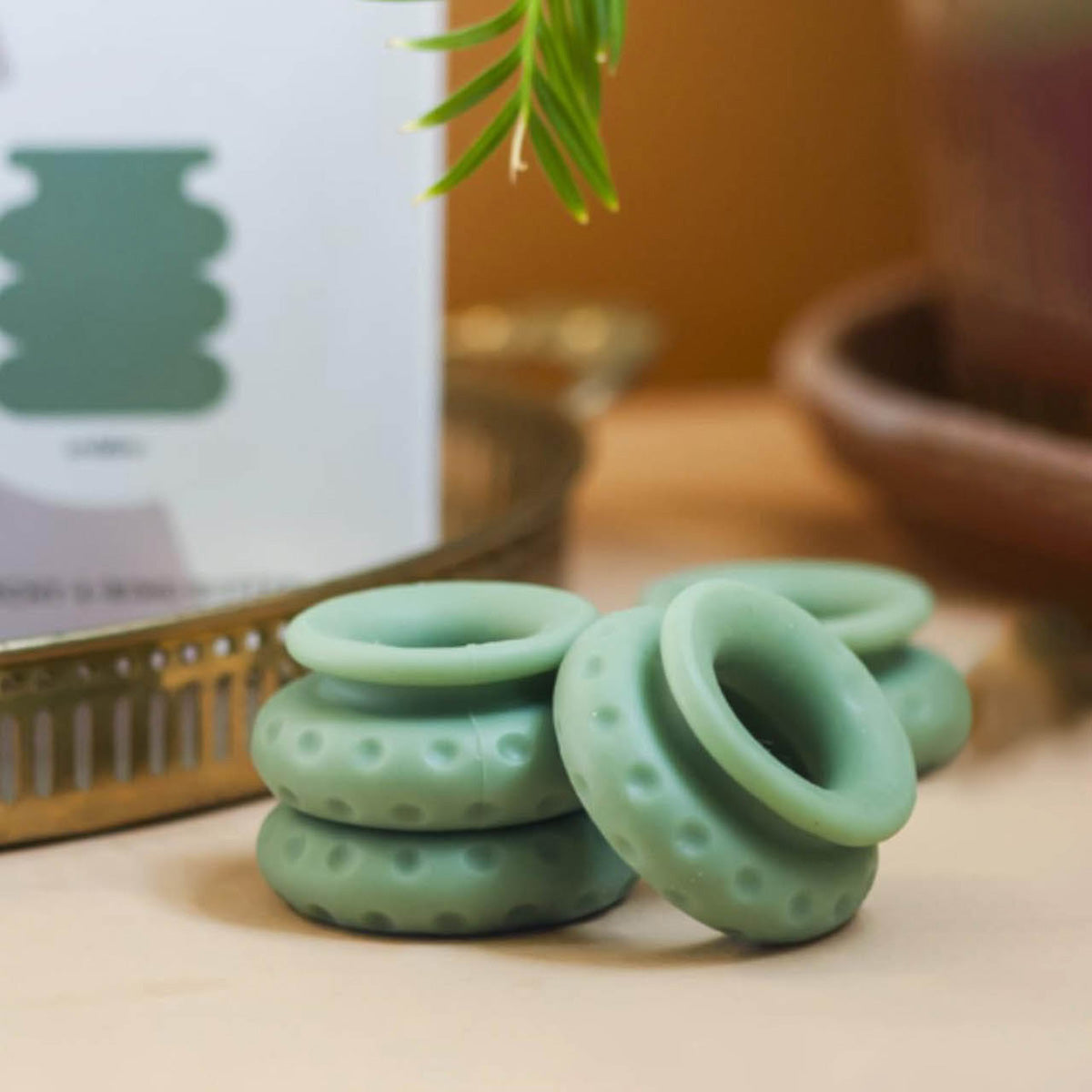 Green textured cock rings on a wooden surface with a blurred background